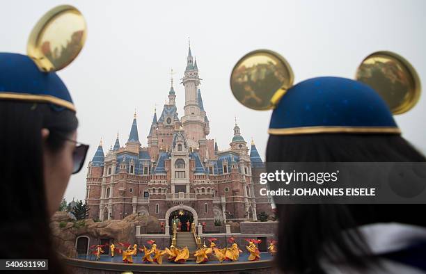 Women wearing Mickey Mouse ears watch the opening ceremony of the Shanghai Disney Resort in Shanghai on June 16, 2016. Entertainment giant Disney...