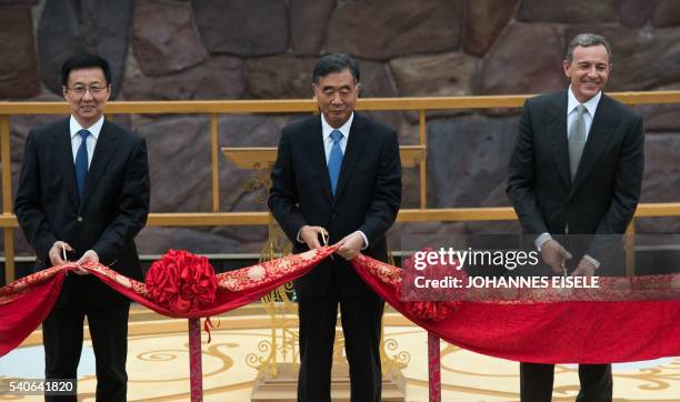 Shanghai Mayor Han Zheng, Chinese Vice Premier Wang Yang and chairman and CEO of Walt Disney, Bob Iger, cut a red ribbon during the opening ceremony...