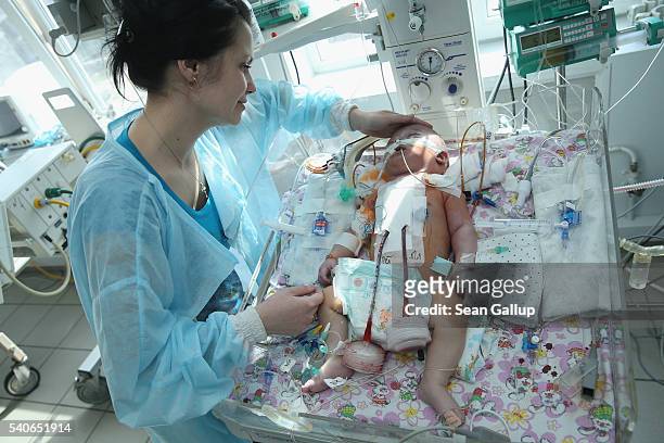 Snyezhana Tertishneya strokes her son Ruslan, aged three months, following his operation to correct severe birth defects in his heart at the cardiac...