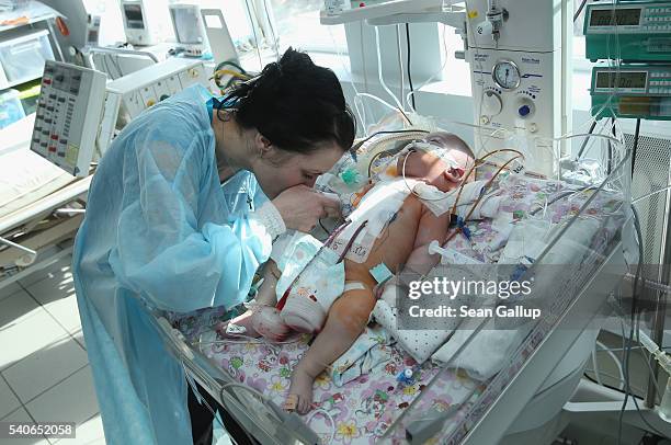 Snyezhana Tertishneya kisses the hand of her son Ruslan, aged three months, following his operation to correct severe birth defects in his heart at...