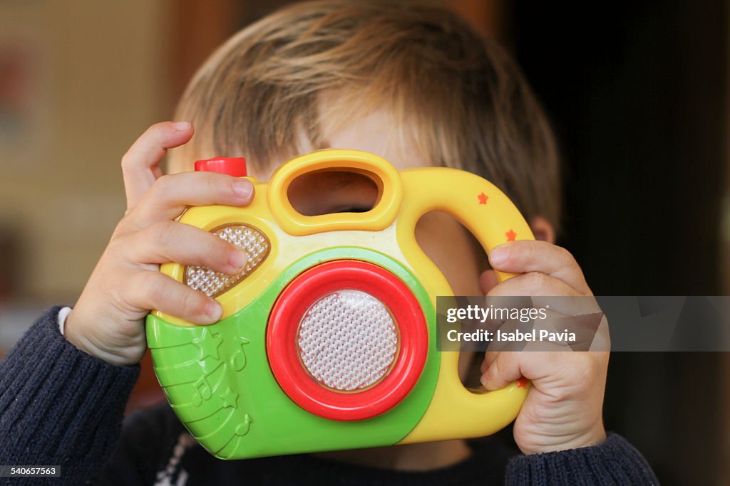 Boy looking through toy camera