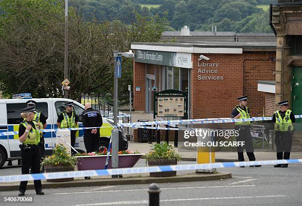 Police stand guard on the perimeter of the crime scene outside the library in Birstall where Labour MP Jo Cox was shot on June 16, 2016. Campaigning...