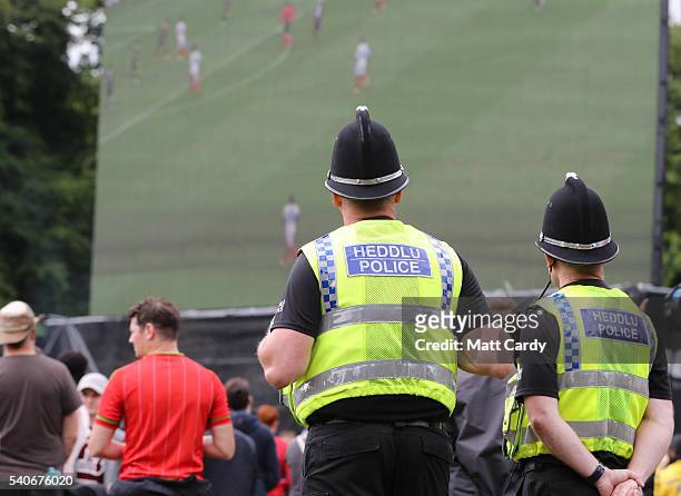 Police officers watch the giant screen as Welsh fans gather to watch the UEFA EURO 2016 Group B match between England and Wales on June 16, 2016 in...