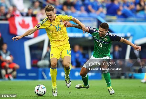 Serhiy Sydorchuk of Ukraaine and Oliver Norwood of Northern Ireland compete for the ball during the UEFA EURO 2016 Group C match between Ukraine and...