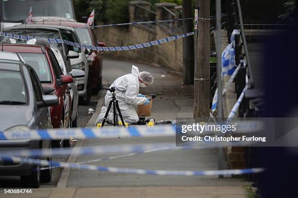 Forensic police examine and place a shoe into an evidence bag at the scene after Jo Cox Labour MP for Batley and Spen, was shot and stabbed by an...