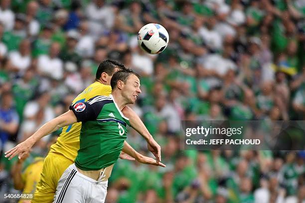 Ukraine's defender Artem Fedetskiy and Northern Ireland's defender Jonny Evans vie for the ball during the Euro 2016 group C football match between...