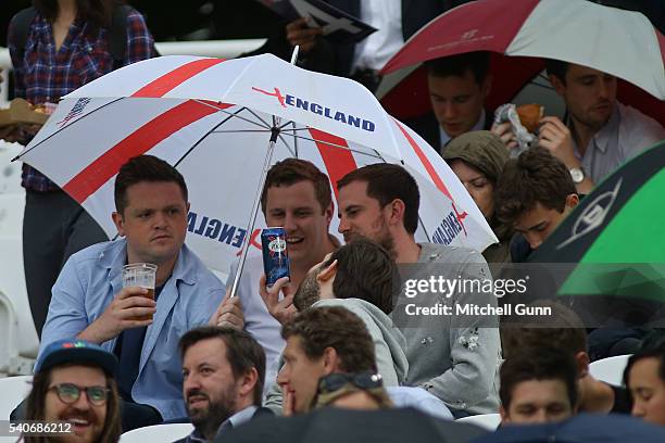 Fans under an umbrella during a rain shower before the start of play at the NatWest T20 Blast match between Middlesex and Sussex at Lords Cricket...