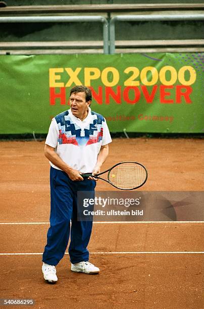 Der Landesvorsitzende der SPD in Niedersachsen Gerhard Schröder beim Tennis spielen. Er hält einen Tennisschläger in der Hand. Im Hintergrund ist auf...