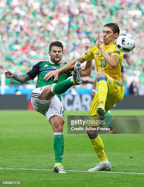 Denys Garmash of Ukraine and Oliver Norwood of Northern Ireland compete for the ball during the UEFA EURO 2016 Group C match between Ukraine and...