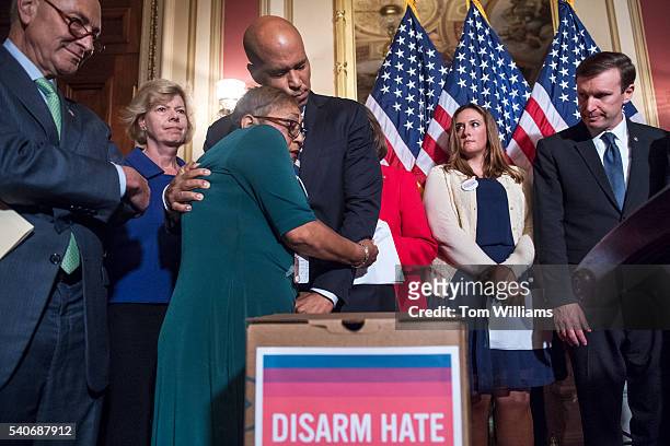 Sen. Cory Booker, D-N.J., hugs Sharon Risher, whose mother and two cousins were killed in the 2015 Charleston, S.C., shooting, during a news...