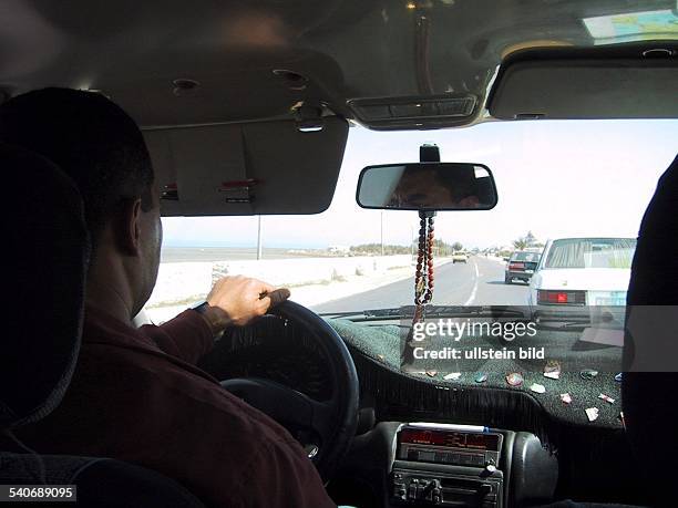 Durch die Windschutzscheibe bietet sich dem Fahrgast eines tunesischen Taxifahrers auf Djerba der freie Blick auf die Straße. Auto; Tunesien;...