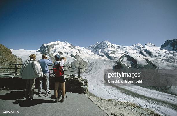 Gornergrat bei Zermatt: Wanderer bestaunen von der Aussichtsterrasse die Eiswelt der Viertausender der Walliser Alpen. An Monte Rosa, Liskamm und...