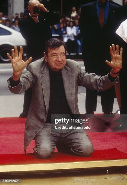 Matthau, Walter *01.10..2000+Schauspieler, USA- kniet auf einem roten Teppich und hebt die Haende- 1998