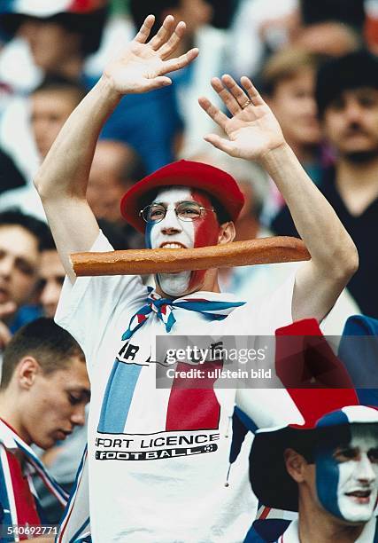 Fußballweltmeisterschaft 1998 in Frankreich. Ein französischer Fan jubelt in Paris der Nationalmannschaft seines Landes mit erhobenen Armen zu. Er...