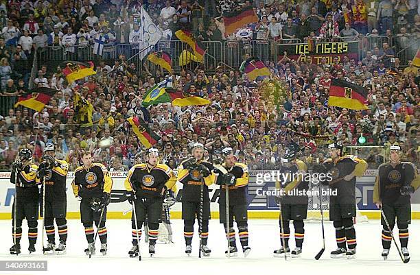 Die Deutsche Eishockey-Nationalmannschaft, in einer Reihe auf dem Eis, während der Eishockey-WM 2001 in Köln. Im Hintergrund Zuschauer mit...