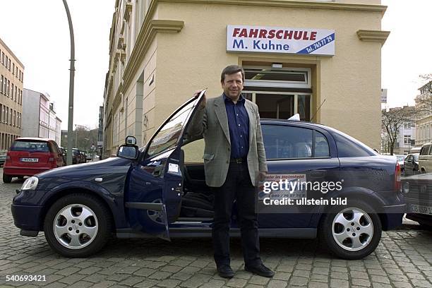 Fahrlehrer Matthias Kuhne vor einem Fahrschulwagen seiner Fahrschule in Harburg. .