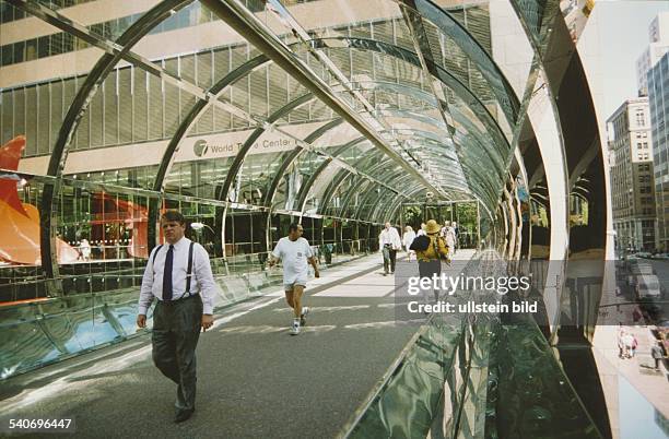 Passanten überqueren eine überdachte Straßenüberführung zum 'World Trade Center' in Manhattan, New York. Der Übergang, bestehend aus Glas und...