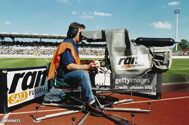 Ein Kameramann des Senders SAT 1 sitzt auf einem drehbarem Kamerastuhl am Rande des voll besetzten VFL Stadions in Wolfsburg. Er filmt für die...