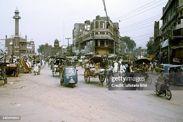 Fahrräder, Rikschas, Mopeds und Pferdefuhrwerke in der Altstadt von Lahore. Straßenszene; Verkehr. .