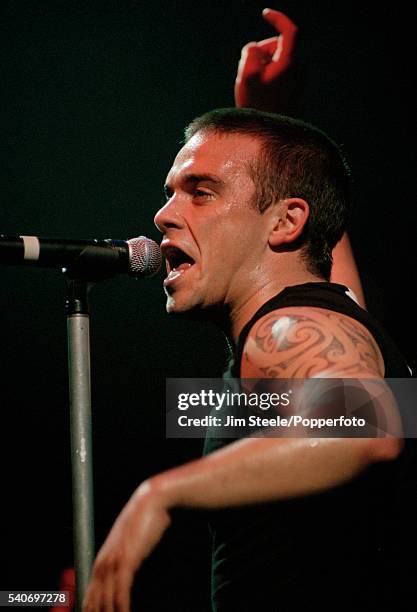 Robbie Williams performing on stage during the NetAid Concert held at Wembley Stadium in London on the 9th October, 1999.