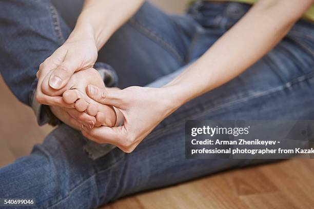 woman with foot injury making self massage - hornhaut stock-fotos und bilder