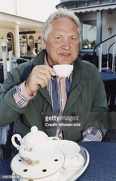 Der Kurdirektor von Bad Oeynhausen, Garrelf Remmers. Er hält eine Teetasse in der Hand. Im Vordergrund eine Teekanne mit Stövchen . .