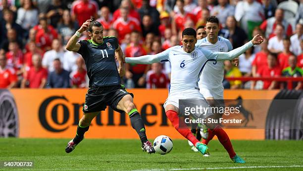 Chris Smalling of England challenges Gareth Bale of Wales during the UEFA Euro 2016 Group B match between England and Wales at Stade Bollaert-Delelis...