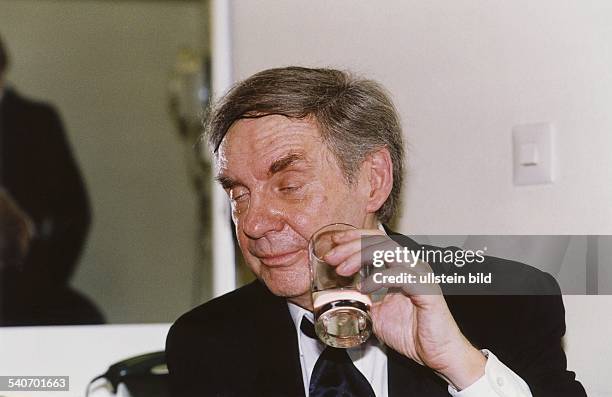 Der deutsche Schauspieler und Entertainer Harald Juhnke hält ein Glas mit Alkohol in der Hand. .