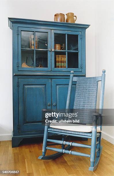 Schrank und Schaukelstuhl im Landhausstil. .