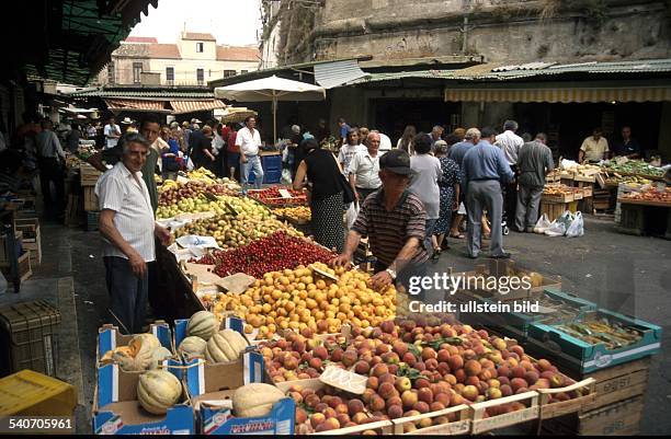 Auf einem gut besuchten Markt in Kalabrien wird an mehreren Ständen frisches Obst und Gemüse angeboten. .