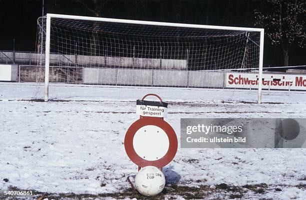 Fußball: Wegen Schneefalls ist der Rasen des Fußballplatzes nicht bespielbar. Ein auf dem Platz aufgestelltes Verkehrszeichen mit einem zusätzlich...