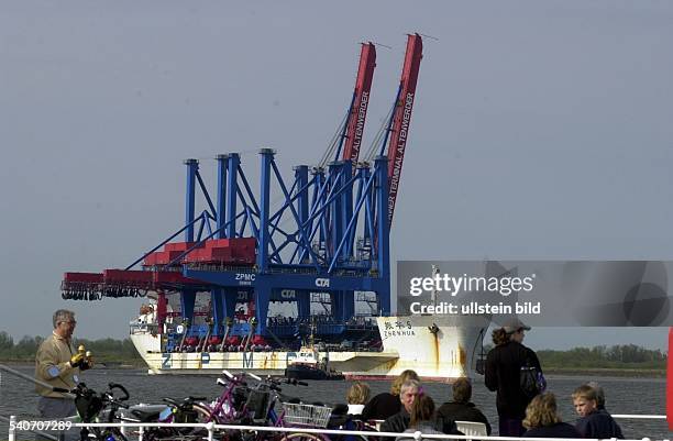 Spezialfrachter 'Zhen Hua 5' mit zwei Containerbrücken auf dem Weg nach Hamburg bei Twielenfleth auf der Elbe. Im Vordergrund Passagiere auf einer...