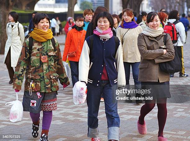 Junge Frauen in Tokio. Modern und leger gekleidet in Nato-Parker, Wollschals, Baseballjacke, Minirock und Jeans bummeln sie mit ihren Einkaustüten...