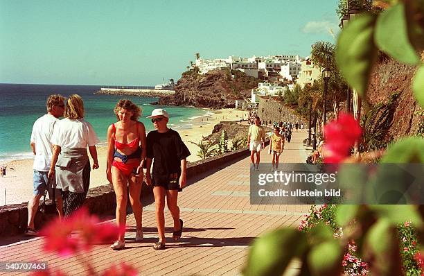 Fuerteventura : Urlauber bummeln, zum Teil leicht bekleidet, auf einer Strandpromenade nahe Jandia Playa, dem touristischen Zentrum im Süden der...