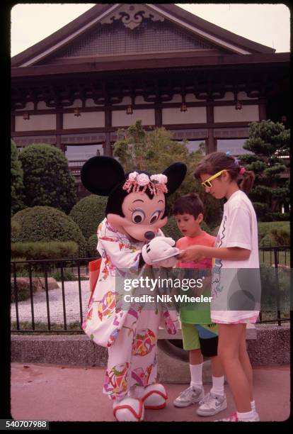 Minnie Mouse signs an autograph for children outside the Japan pavilion at EPCOT Center's World Showcase in Florida's Walt Disney World.