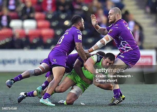 Ben Flower of Wigan Warriors is tackled by Aaron Heremaia and Paddy Flynn of Widnes Vikings during the First Utility Super League Round 19 match...