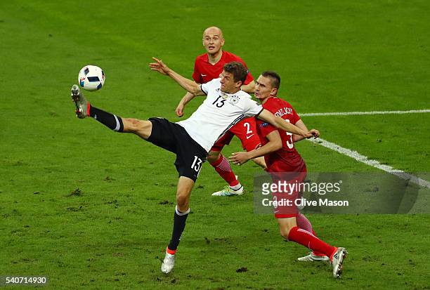 Thomas Mueller of Germany and Artur Jedrzejczyk of Poland compete for the ball during the UEFA EURO 2016 Group C match between Germany and Poland at...
