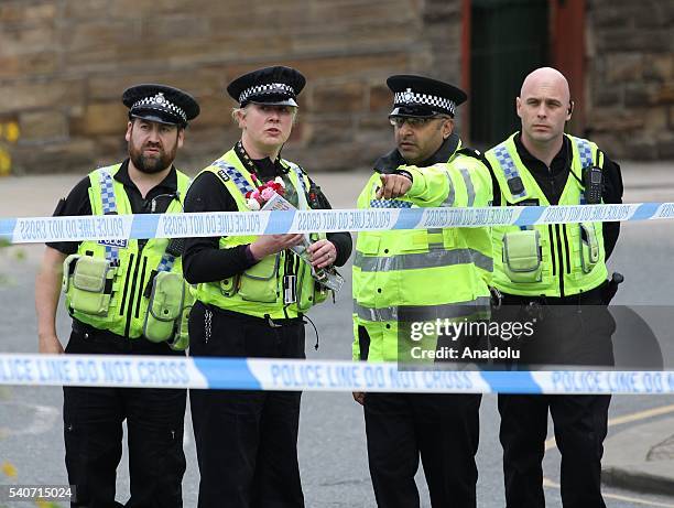 Police officer is seen with the bunch of flowers at a statue of Joseph Priestley after the murder of Jo Cox Labour MP, who was shot and stabbed by an...