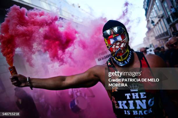 Docker holds a flare as he demonstrates with hundreds of others against low wages, collective layoffs and insecurity at the workplace in Lisbon on...