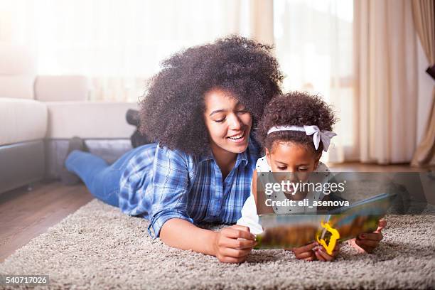 mother reading a book to her daughter on carpet - girls of the sun red carpet arrivals the 71st annual cannes film festival stockfoto's en -beelden