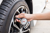 Close-Up Of Hand holding pressure gauge for car tyre
