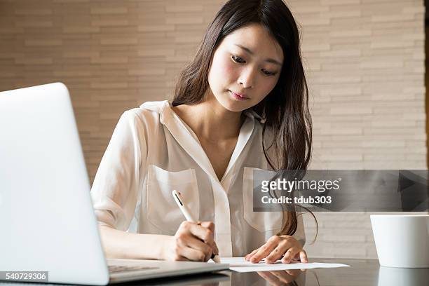 woman filling out important paper documents - contract paper stock pictures, royalty-free photos & images
