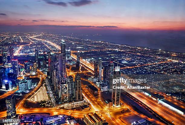 elevated cityscape of dubai illuminated at dusk - united arab emirates aerial stock pictures, royalty-free photos & images