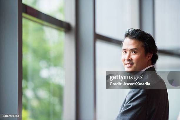 asian businesman in a conference foyer - lypsekyo16 stockfoto's en -beelden
