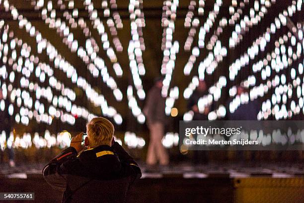 people interacting with light installation - amsterdam light festival stock pictures, royalty-free photos & images