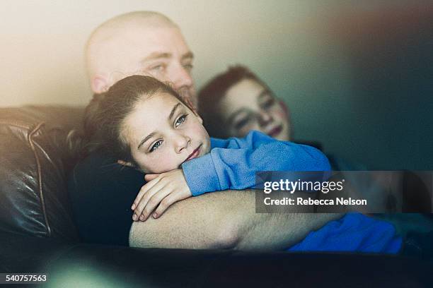 Son and daughter sitting on dad's lap