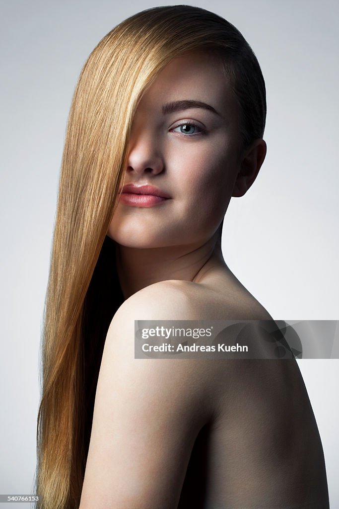 Bare teenage girl with long, shiny hair, portrait.