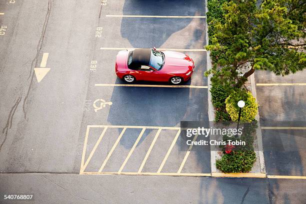 red sports car in a parking lot seen from above - chris motionless - fotografias e filmes do acervo