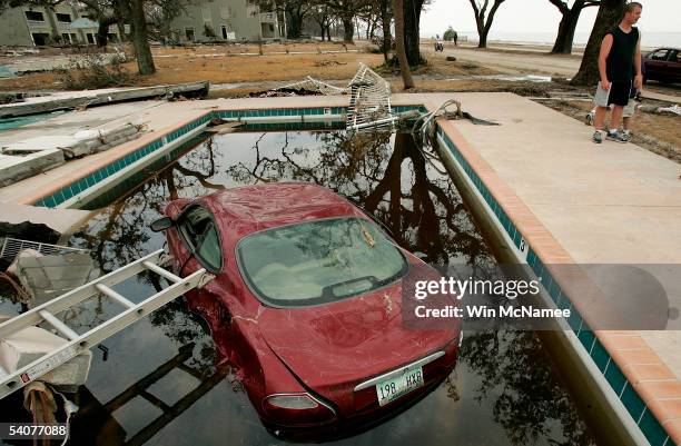 Car rests partially submerged in a swimming pool outside an apartment building destroyed by Hurricane Katrina September 1, 2005 in Biloxi,...