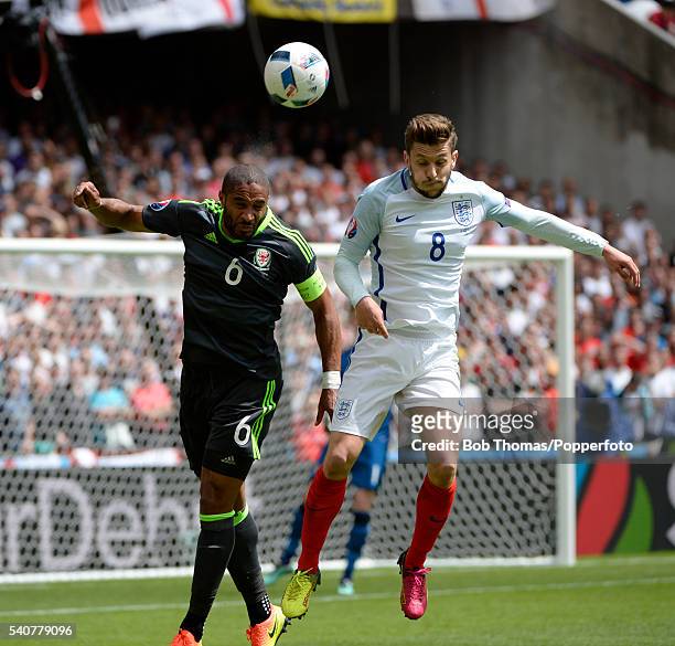 Adam Lallana of England heads the ball with Ashley Williams of Wales during the UEFA EURO 2016 Group B match between England and Wales at Stade...